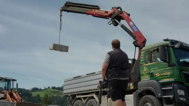 schmid_erdbau_job-portal_kran-LKW-fahrer_heben_von_betonblock